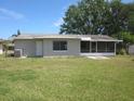 Shows the back exterior of the home, featuring a screened-in patio area and a window at 2936 Lantern Dr, South Daytona, FL 32119