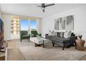Bright living room featuring stylish furnishings, a ceiling fan, and a large sliding glass door to the balcony at 2947 S Atlantic Ave # 201, Daytona Beach Shores, FL 32118