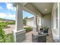 Inviting front porch features stately columns and brick pavers, perfect for enjoying quiet moments outdoors at 302 Lamberton Ln, Deland, FL 32724