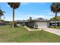Lovely single-story home featuring a two-car garage, mature landscaping and a well-maintained lawn at 303 E Floral Ave, Eustis, FL 32726