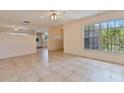 Bright living room featuring tile floors, large windows and a ceiling fan at 303 E Floral Ave, Eustis, FL 32726