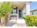 Inviting front porch with a bench, welcome sign, and lush landscaping at 3128 Crab Trap Dr, New Smyrna Beach, FL 32168