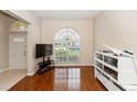 Bright living room with hardwood floors, a large arched window, and a clear view of the home's exterior at 316 Oak Springs Dr, Debary, FL 32713