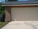 Spacious two car garage with a beige garage door on a sunny day at 3259 Ellwood Ct, Winter Park, FL 32792