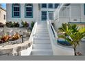 Elegant stairway leading to the front door, enhanced by colorful landscaping and a stone retaining wall at 4363 S Atlantic Ave, Ponce Inlet, FL 32127
