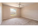 Cozy bedroom with neutral carpet, a ceiling fan, and a bright window at 4589 Alder Dr, Port Orange, FL 32127
