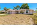 Beautiful home exterior featuring a manicured lawn, an attached garage, and mature trees at 4589 Alder Dr, Port Orange, FL 32127