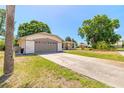 Spacious driveway leading to a well-kept home with a manicured lawn and mature trees at 4589 Alder Dr, Port Orange, FL 32127