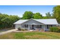 Charming single-story home with a new silver metal roof, inviting front porch, manicured lawn and mature landscaping at 4836 Ne 26Th Ter, Ocala, FL 34479