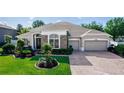 Beautifully landscaped single-story home with a brick driveway and well-maintained lawn at 4901 Lake Milly Dr, Orlando, FL 32839