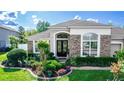 Inviting front entrance with stone details and lush landscaping at 4901 Lake Milly Dr, Orlando, FL 32839