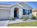 Inviting front entrance with meticulously landscaped garden beds, enhancing curb appeal and charm at 5298 Bear Corn Run, Port Orange, FL 32128