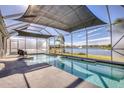 Sparkling pool with a built-in waterfall feature, all within a screened enclosure overlooking the tranquil lake at 5298 Bear Corn Run, Port Orange, FL 32128
