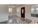 Inviting foyer showcasing new tile flooring and an ornate front door and natural light at 600 Holmes Ave, Daytona Beach, FL 32114