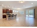 Open-concept living space boasts tile flooring, a modern kitchen island, and sliding glass doors to bring the outdoors in at 669 E Victoria Trails Blvd, Deland, FL 32724