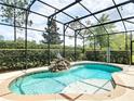 Inviting screened-in pool featuring a rock waterfall, statue, and surrounding lush landscaping for a serene outdoor oasis at 669 E Victoria Trails Blvd, Deland, FL 32724