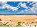 Expansive beach view showcasing beautiful blue skies and ocean waves along sandy shore at 787 Ocean Shore Blvd, Ormond Beach, FL 32176