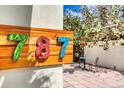 Wooden sign displaying the colorful house number '787' with outdoor patio view at 787 Ocean Shore Blvd, Ormond Beach, FL 32176