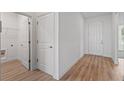 Bright hallway featuring wood-look flooring, white trim, and multiple access doors at 810 W 24Th St, Sanford, FL 32771