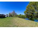Expansive backyard with lush greenery, leading to a tranquil waterfront view, perfect for relaxation at 950 Windway Cir, Kissimmee, FL 34744
