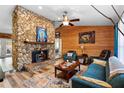 Inviting living room featuring a stone fireplace, wood paneling, and comfortable seating at 1560 S Pearl St, Deland, FL 32720