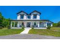 Charming two-story modern farmhouse with inviting front porch and well-maintained landscaping at 1015 Tallacoe Trl, New Smyrna Beach, FL 32168
