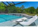 Gorgeous pool with fountains and underwater seating, set against a backdrop of lush trees at 1015 Tallacoe Trl, New Smyrna Beach, FL 32168