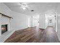 Spacious living room featuring wood flooring, white walls, ceiling fan, and a fireplace at 1054 Abeline Dr, Deltona, FL 32725