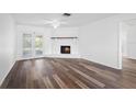 View of the living room featuring laminate floors, a ceiling fan, and a brick fireplace at 1054 Abeline Dr, Deltona, FL 32725