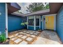 Inviting entryway with a yellow front door, stone pathway, and decorative plants adding a touch of charm at 1206 Parkside Dr, Ormond Beach, FL 32174