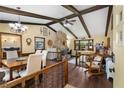 Cozy living room featuring a stone fireplace, wood beams, and hardwood floors providing a warm ambiance at 1206 Parkside Dr, Ormond Beach, FL 32174