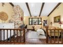 Comfortable living room featuring a stone fireplace, wood beams, and large windows offering natural light at 1206 Parkside Dr, Ormond Beach, FL 32174