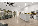 Open-concept living space with tiled floors, vaulted ceilings, and a modern kitchen island at 1440 Portola Ave, Deltona, FL 32738