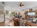 Open-concept living room showcasing hardwood floors, a cozy fireplace, and an adjacent kitchen and dining area at 1550 11Th Ave, Deland, FL 32724