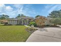 Inviting front exterior showcasing a well-manicured lawn, mature landscaping, and a charming entryway at 1661 Timber Hills Dr, Deland, FL 32724