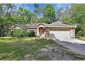 Single-story brick home featuring an attached garage and mature landscaping in a serene setting at 1925 Hamilton Ave, Orange City, FL 32763