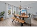Dining room with wood table, a bench, modern chandelier, and sheer curtains at 199 Verde Way, Debary, FL 32713