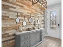 Stylish entryway features a wood accent wall, gray dresser, and a decorative light fixture at 199 Verde Way, Debary, FL 32713