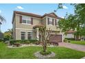 Two-story home with a red tile roof and brown shutters, complemented by a landscaped yard and a brick driveway at 199 Verde Way, Debary, FL 32713