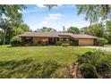 Beautiful brick home with a well-manicured lawn, lush greenery, and charming architectural details that enhance its curb appeal at 229 Riverbend Rd, Ormond Beach, FL 32174