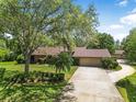 Stunning shot of the brick home, long driveway and lush landscaping at 229 Riverbend Rd, Ormond Beach, FL 32174