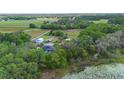 Aerial view featuring the home, storage building, RV, mature trees, and a serene pond at 2395 Old Reynolds Rd, De Leon Springs, FL 32130