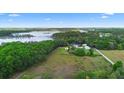 Expansive aerial view of the property, showcasing the home, surrounding land, lake, and lush greenery at 2395 Old Reynolds Rd, De Leon Springs, FL 32130