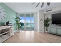 Bright living room with light wood floors, ocean decor, and expansive windows with waterfront views at 241 Riverside Dr # 304, Daytona Beach, FL 32117