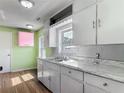 Cozy kitchen featuring white cabinets and countertops with a double basin stainless steel sink at 243 S Hull Ave, Deland, FL 32720