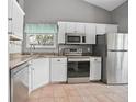 Well-lit kitchen featuring stainless steel appliances and granite countertops at 2596 Lancaster Ct, Apopka, FL 32703