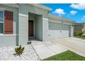 Close up shot of a welcoming single-story home featuring a two-car garage and meticulously landscaped front yard at 2686 Neverland Dr, New Smyrna Beach, FL 32168