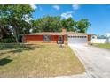 Charming brick home with a manicured lawn and mature trees in a quiet neighborhood at 291 Sagewood Dr, Port Orange, FL 32127