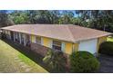 Aerial side view of a yellow ranch style home featuring a brick facade, lawn, and a two car garage at 2919 Griffin Rd, Leesburg, FL 34748