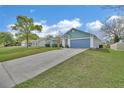 Well-maintained home featuring a long driveway leading to an attached garage, surrounded by a green lawn at 2937 Garret St, Deltona, FL 32738